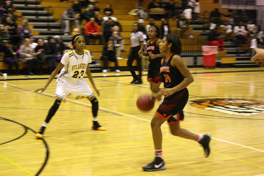 Morgan Hill dribbles the ball towards the basket. Hill plays the majority of the time, in most games, and scores an average of 20 points a game. 
