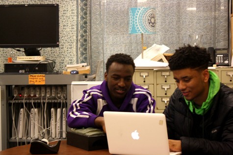 Senior Lataa Elemo and junior Nate Mamo hang out in front of one of the writing center's Mac computers. 