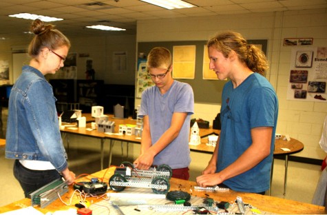 Ella Johnstad (10), Max Baker (12), and William McConnell (12) work on their robot.