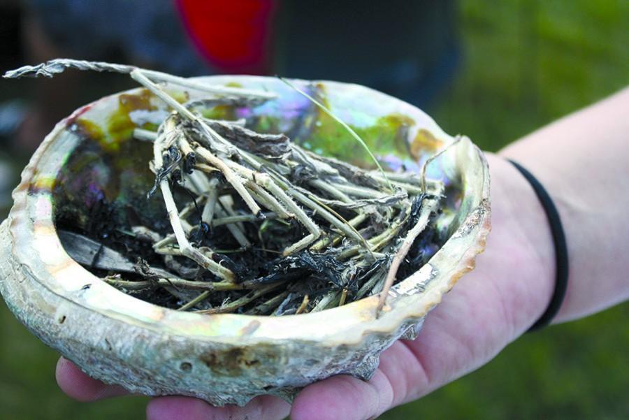 An All Nations student holds an abalone shell filled with sage in preparation for smudging at the back-to-school Welcoming Ceremony in 2013.  Students in the program can participate in smudging daily before school.