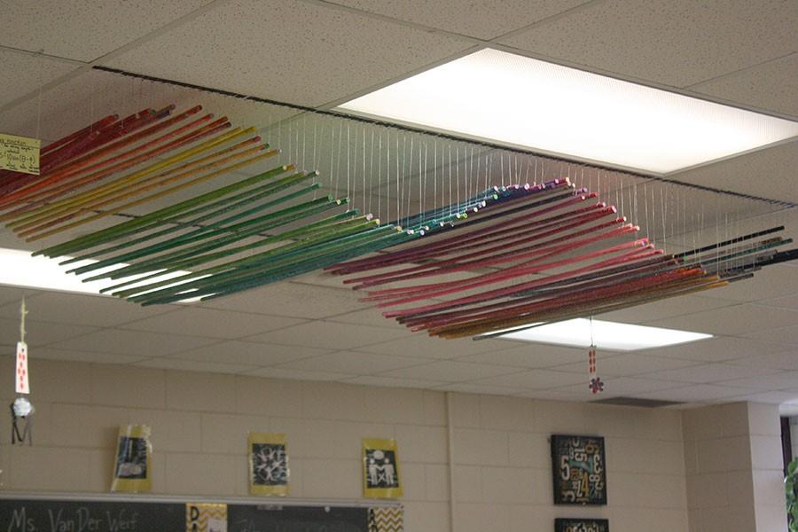 “One of them is made out of, I think, a hundred dowels that are three or four feet long, and we colored them all, and of course used a copious amount of glitter. And the math part of it was that students had to actually use an equation to figure out how long to cut their strings, and then when you’d put it all together it created a sine wave,” said Woldum about the colorful sculpture hanging from the center of the ceiling in her classroom.
