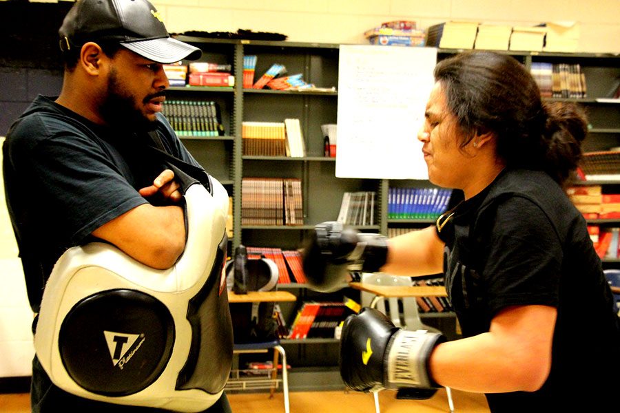 Andrew Fohrenkam practices his punches against coach Cerresso Fort. Fort finds that boxing “takes techniques and skills and you got to use your mind and brain to think. It’s good to be healthy.”  Picture: Gabe Chang-Deutsch
