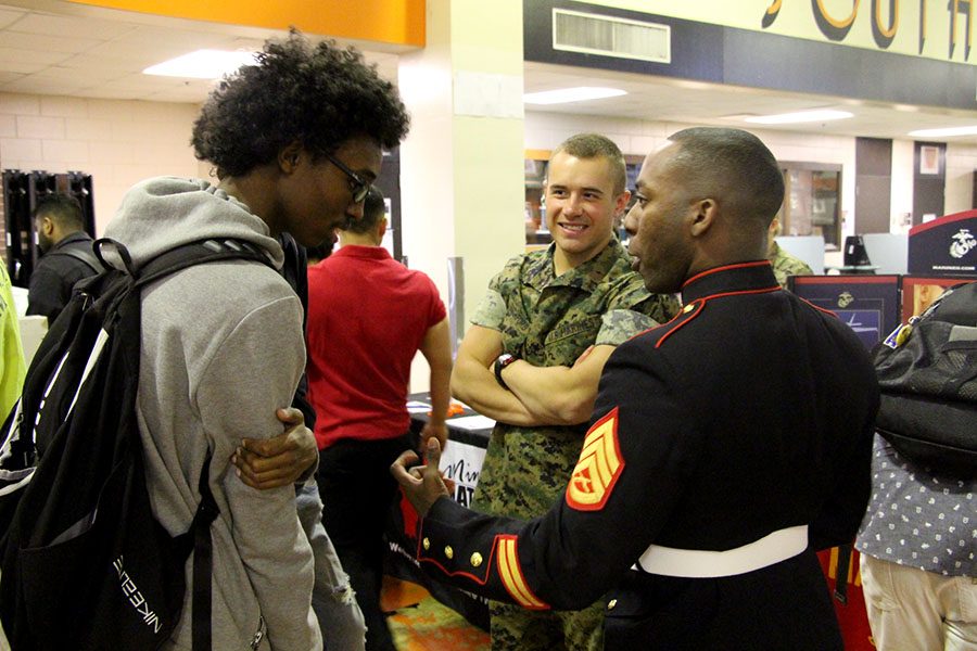 Staff Sergent Clevon Clarke and Private First Class Griffin Ruthford, talk to junior Abdifitah Farah about the opportunity that the Marine Corps provides. The Marine Corps are one of the six branches that possible enlistees can choose to go into. 