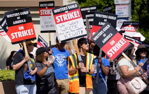 Striking writers picketing outside of Paramount Pictures studio with signs that read: We wont WRITE for less than whats RIGHT, and Its like Newsies but with writers.